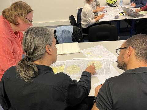 Trois personnes regardent une carte de données